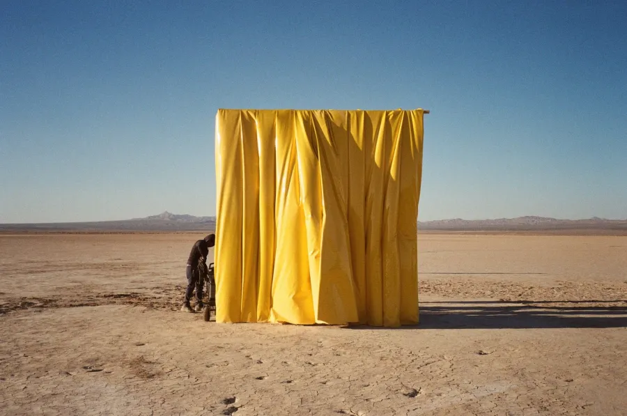 The yellow curtain going up in the desert for All Is Yellow, photographed on set by Jaron Flynn